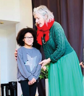 a women is holding and talking to a school age child